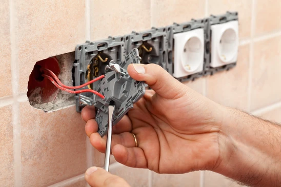 Int&eacute;rieur r&eacute;sidentiel, mains d'&eacute;lectricien installant des prises &eacute;lectriques murales