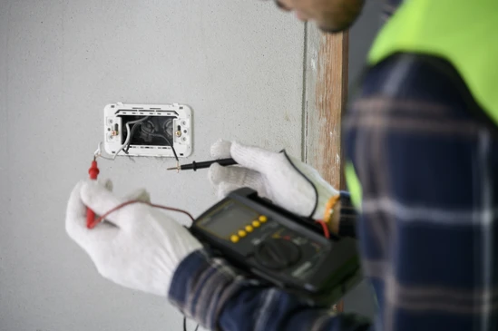 &Eacute;lectricien de construction de maison utilisant voltm&egrave;tre v&eacute;rifier fil &eacute;lectrique qui a &eacute;t&eacute; pr&eacute;par&eacute; et installer avant d'assembler interrupteur de lumi&egrave;re pour la proc&eacute;dure de travail de s&eacute;curit&eacute;