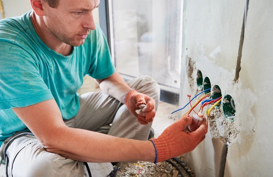 &Eacute;lectricien Avec Apprentis Travaillant Dans Une Nouvelle Maison